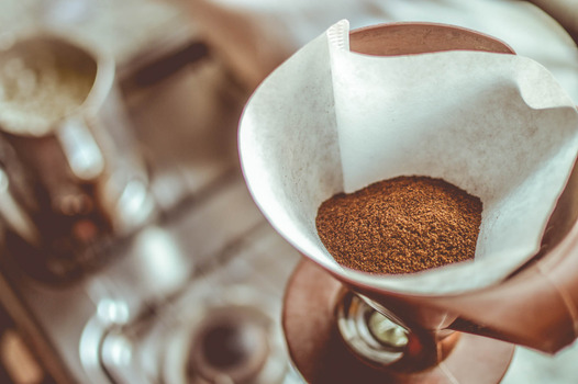 A close-up of a paper filter filled with ground coffee